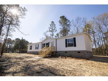 Charming single story home with wooden front porch and black shutters and a beautiful outdoor space at 2293 Old Hwy 6, Cross, SC 29436