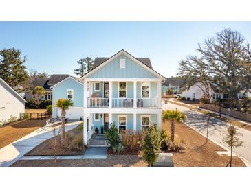 Charming two-story light blue home with a double front porch and well manicured landscaping at 2545 Hatch Dr, Johns Island, SC 29455