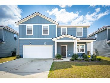 Charming two-story home with blue siding, a well-manicured lawn, and an attached two-car garage at 284 Shadybrook Dr, Summerville, SC 29486