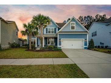 Charming two-story home with a well-manicured lawn, palm trees, and a two-car garage at 306 Long Pier St, Summerville, SC 29486