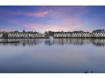 Waterfront condos view featuring a fountain at sunset with balconies and private boat dock at 4789 Arco Ln, North Charleston, SC 29418