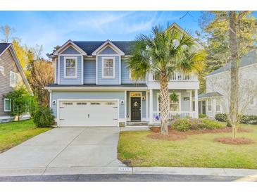 Charming two-story home with a light blue facade, manicured lawn, and mature palm tree at 5415 Clairmont Ln, North Charleston, SC 29420