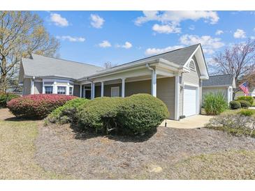 Beautiful exterior of a home featuring lovely landscaping and an attached two-car garage at 9021 Delancey Cir, North Charleston, SC 29406