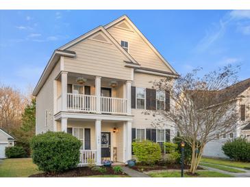 Charming two-story home with a covered porch, white pillars, manicured landscaping, and neutral siding against a blue sky at 103 Avalon Ct, Goose Creek, SC 29445