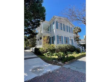Charming two-story home featuring a spacious porch and beautiful blue shutters at 115 Rutledge Ave # A, Charleston, SC 29401