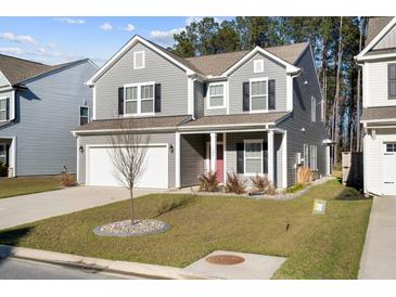 Charming two-story home with gray siding, well-manicured lawn, and a two car attached garage at 128 Surfbird Rd, Summerville, SC 29486