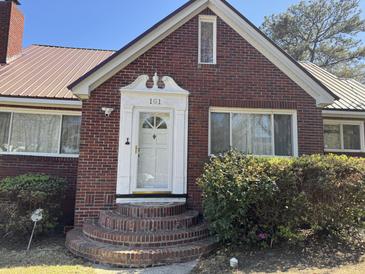 Charming brick home featuring an arched brick staircase leading to a classic white front door at 161 Gordon Street, Charleston, SC 29403