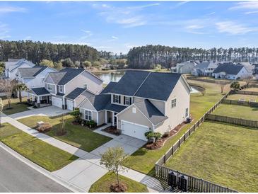 Beautiful two-story home with well-manicured lawn and backyard facing a tranquil pond and a mature tree line at 219 Daybreak Blvd, Summerville, SC 29486