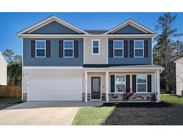 Inviting two-story home showcasing blue and beige siding, complemented by a well-manicured lawn and attached garage at 294 Torslanda Ln, Summerville, SC 29486