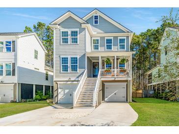 Charming two-story home features a welcoming porch, double garages, and manicured front yard at 312 Coki Amalie Ct, Charleston, SC 29492
