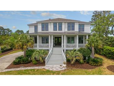 Stunning two-story home with inviting porch, well-manicured lawn, and lush landscaping at 4874 Sound View Dr, Mount Pleasant, SC 29466