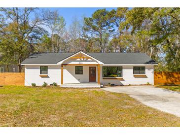 Charming renovated single-story home with a painted brick exterior and inviting front porch at 671 Riley Rd, Charleston, SC 29412