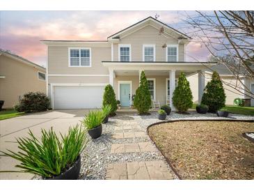 Charming two-story home features a well-manicured front yard, inviting entryway, and attached garage at 166 Pavilion St, Summerville, SC 29483