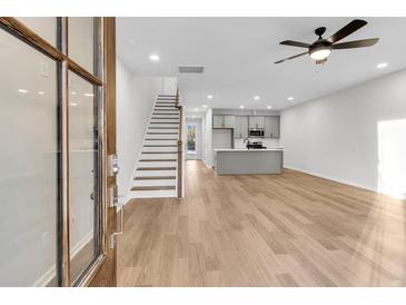 Open-concept living room featuring hardwood floors, neutral paint, and a view of the modern kitchen at 169 Cantona Dr, Summerville, SC 29483