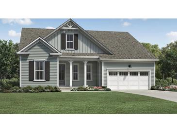 Charming home with a light green exterior, a two-car garage, and a well-manicured lawn at 2010 Riverbend Dr, Charleston, SC 29412