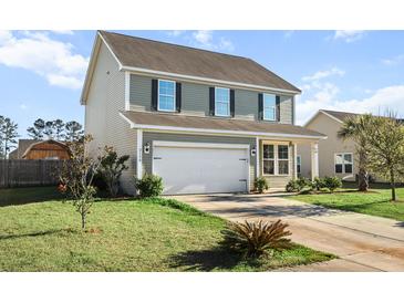 Charming two-story home with siding, a driveway, an attached two car garage, and a well-maintained front lawn at 2150 Pimlico Dr, Ridgeville, SC 29472