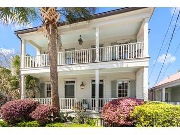 Charming two-story home with double porches, lush landscaping, and a beautiful palm tree in the front yard at 382 Race St # A, Charleston, SC 29403