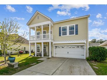 Charming two-story home featuring a double porch, well-maintained lawn, and attached garage at 587 Crossland Dr, Moncks Corner, SC 29461