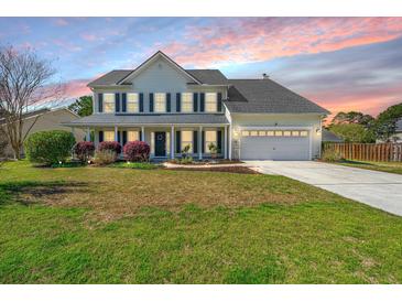 Traditional two-story home with a well-maintained lawn and inviting front porch with black shutters at 9408 Harroway Rd, Summerville, SC 29485