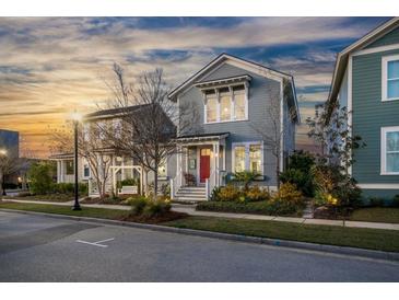 Charming two-story home with a red front door and landscaped yard at dusk at 107 Nutmeg Way, Summerville, SC 29485