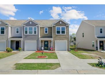 Charming townhome with neat lawn, tidy landscaping, garage, and appealing architectural details at 124 Gaura Ln, Summerville, SC 29483