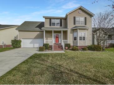 Charming two-story home with a red door, landscaped yard, attached garage, and well-maintained lawn at 159 Antebellum Way, Summerville, SC 29483