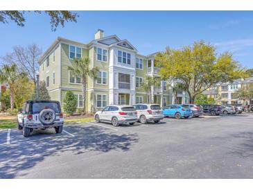 Exterior view of a light green and white multi-story condo building with ample parking at 1822 Chatelain Way, Mount Pleasant, SC 29464