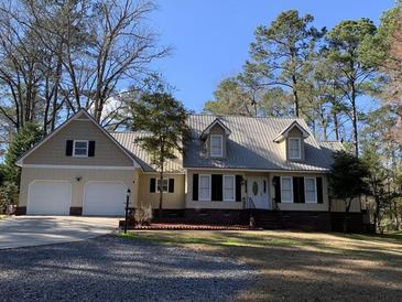 Charming single-story home featuring a metal roof, attached garage, and mature landscaping at 4 Fairway Ct, Walterboro, SC 29488