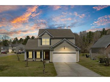 Inviting two-story home with a two car garage, manicured lawn, and picturesque evening sky at 629 English Oak Cir, Moncks Corner, SC 29461