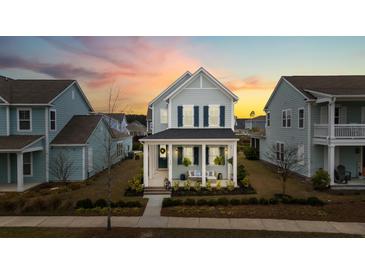 Charming two-story home featuring a welcoming front porch and lovely landscaping, perfect for relaxing evenings at 115 Winding Branch Dr, Summerville, SC 29486