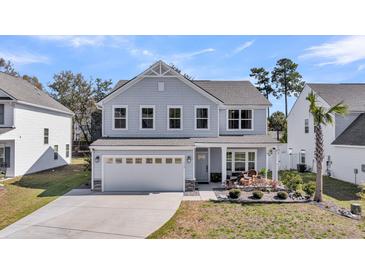 Charming two-story home with a well-manicured front yard and a two-car garage at 134 Country Oaks Ln, Wando, SC 29492