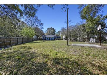 Spacious backyard featuring a basketball court, lawn and wood privacy fence at 1634 Sumner Ave, North Charleston, SC 29406