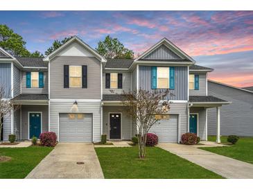Charming townhouse featuring gray siding, a single-car garage, and well-manicured landscaping at 164 Buchanan Cir, Goose Creek, SC 29445