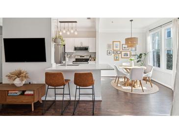 Modern kitchen with white cabinets, stainless steel appliances, and a breakfast bar with brown leather stools at 2022 Chatelain Way, Mount Pleasant, SC 29464