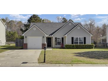 Charming single-story home with gray siding, attached garage, and well-maintained lawn at 306 Slow Mill Dr, Goose Creek, SC 29445