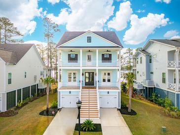 Beautiful two-story home with double front porches, a two-car garage, and lush landscaping at 384 Blowing Fresh Dr, Charleston, SC 29492