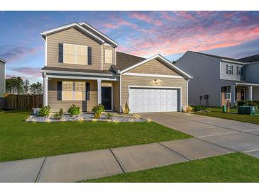Charming two-story home with a well-manicured lawn and a two-car garage at 607 Silver Spruce St, Summerville, SC 29486