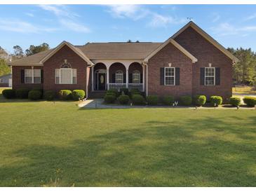 Charming brick home with a well-manicured lawn and inviting front porch at 760 Community Ave, Smoaks, SC 29481