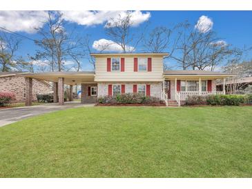 Charming two-story home with a well-maintained lawn, red shutters, a portico, and inviting front porch at 7659 Allwood Ave, North Charleston, SC 29418