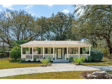 Charming single-story home with a welcoming front porch, landscaped yard, and mature trees at 1515 Devons St, Charleston, SC 29412