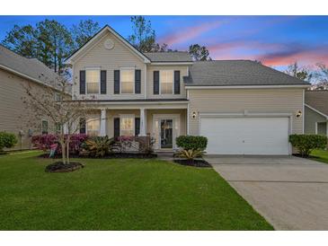 Charming two-story home featuring a well-manicured lawn, flowering bushes, and an attached two-car garage at 184 Charlesfort Way, Moncks Corner, SC 29461
