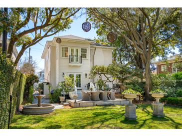 Beautiful backyard featuring a seating area on a stone patio, a fountain and beautiful landscaping at 184 Tradd St, Charleston, SC 29401