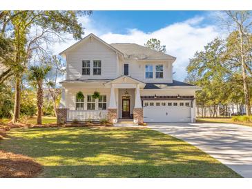 Charming two-story home with a well-manicured lawn and a spacious two-car garage at 233 Ashmont Dr, Wando, SC 29492