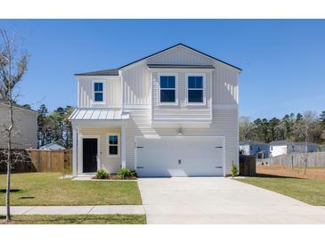 Charming two-story home with attached garage, driveway and landscaped front yard at 455 Minim St, Charleston, SC 29414