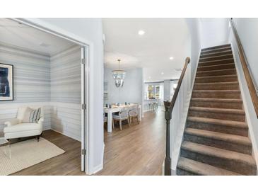Inviting entryway with hardwood floors, a staircase, and an adjacent sitting room featuring stylish decor at 517 Verdi Dr, Summerville, SC 29486