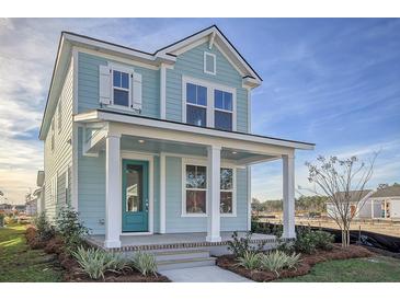 Charming two-story home featuring a covered front porch with white columns and a teal front door at 717 Rumbling Leaf Ln, Summerville, SC 29486