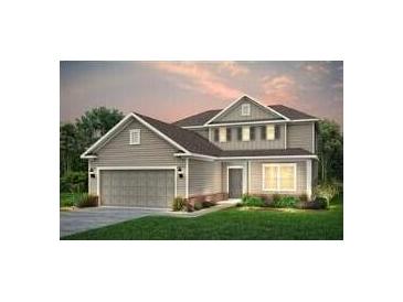 Charming two-story home with a manicured lawn and a two-car garage, offering classic curb appeal at 125 Royal Cainhoy Way, Huger, SC 29450
