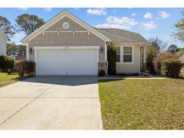 Charming single-story home with a two-car garage, beautiful landscaping, and well-maintained lawn at 1309 Basketweaver Way, Hanahan, SC 29410
