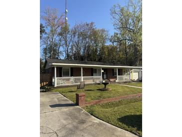 Charming brick ranch-style home with a well-manicured lawn and inviting front porch at 1861 Jaywood Cir, Charleston, SC 29407