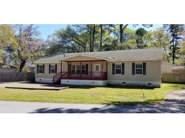 Ranch style home featuring a covered front porch, lawn, and mature shade trees at 1925 Old Parsonage Rd, Charleston, SC 29414